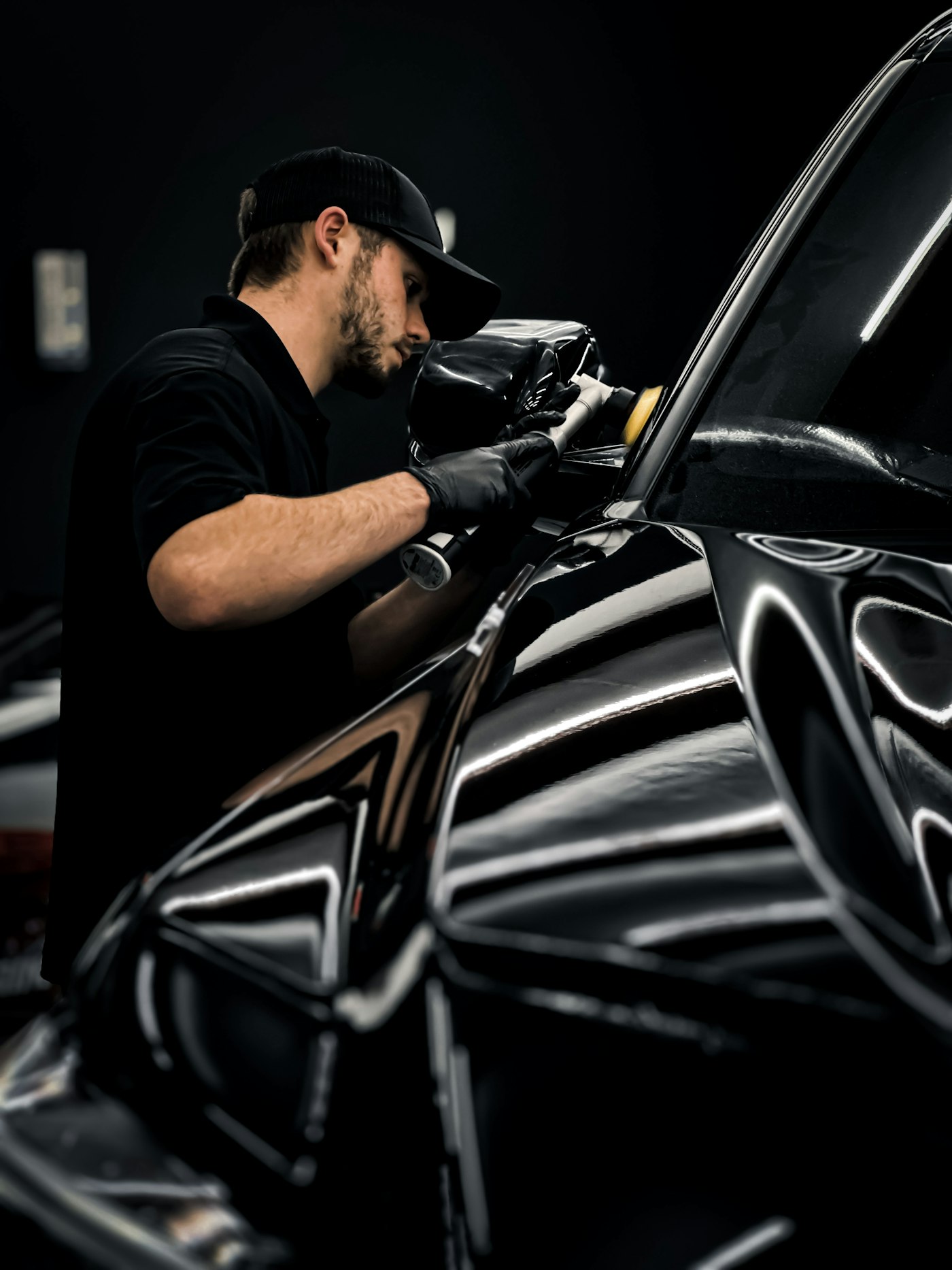 Detailer waxing a car in a garage