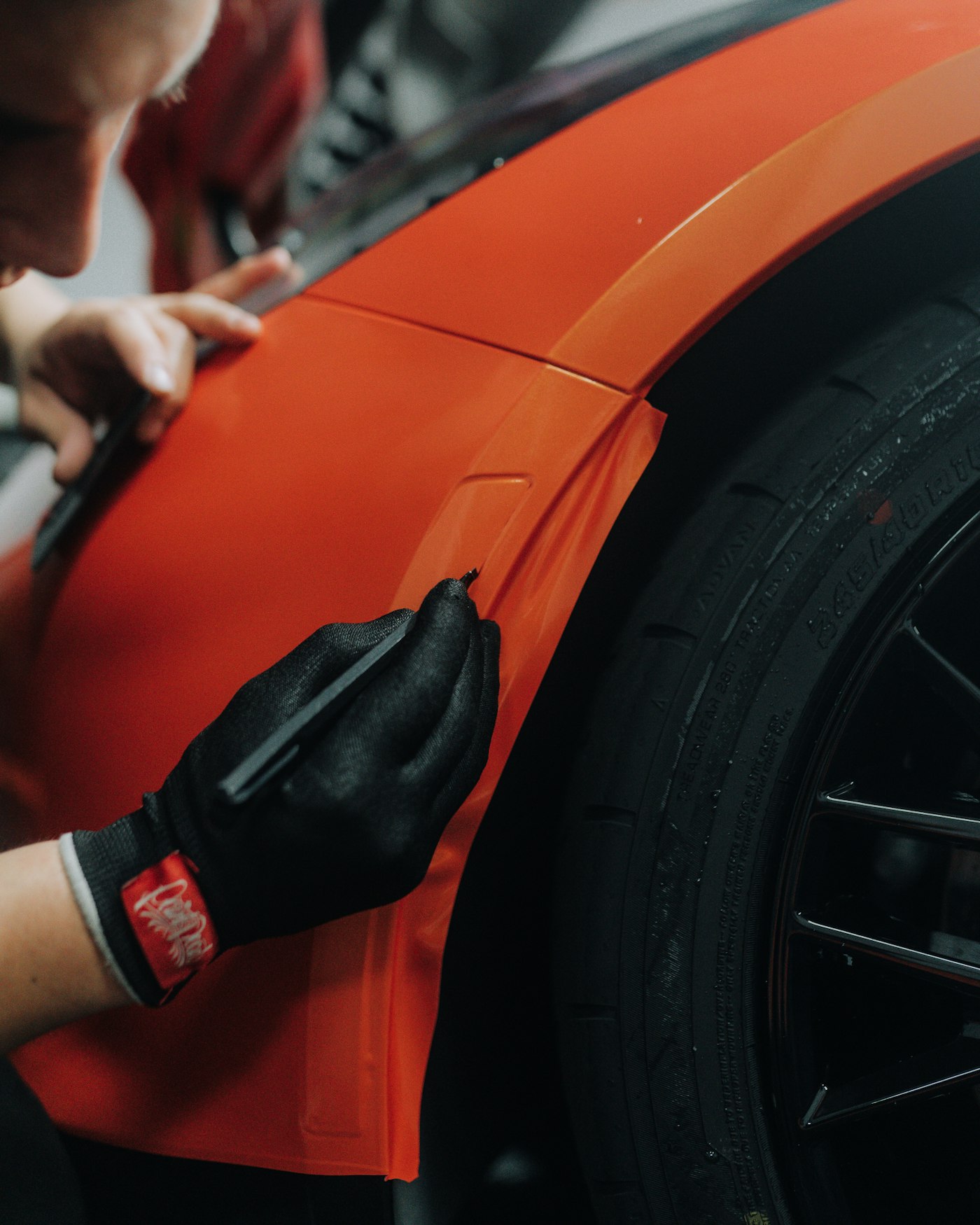 Installer working on an orange vehicle in a garage
